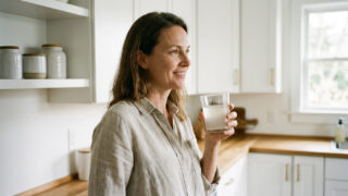 mujer adulta sosteniendo una taza de colágeno con expresión serena, representando los beneficios integrales del colágeno hidrolizado